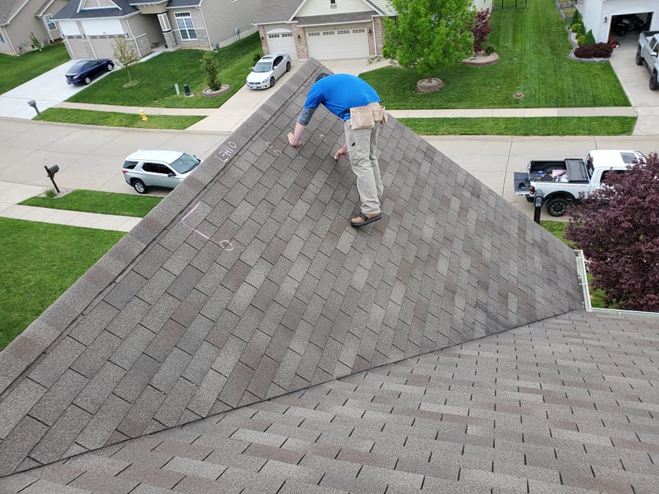 Roof inspection by worker in residential area