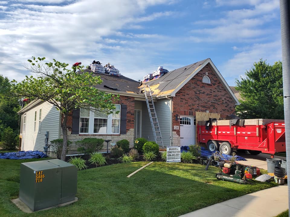 Roofing shingles services — roofer working on active job site